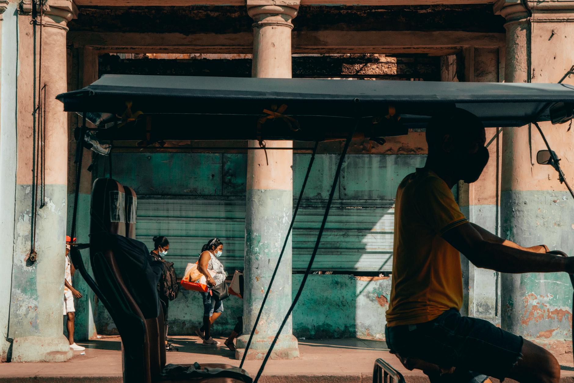 Riksza na zatłoczonej karaibskiej ulicy między starymi kamienicami